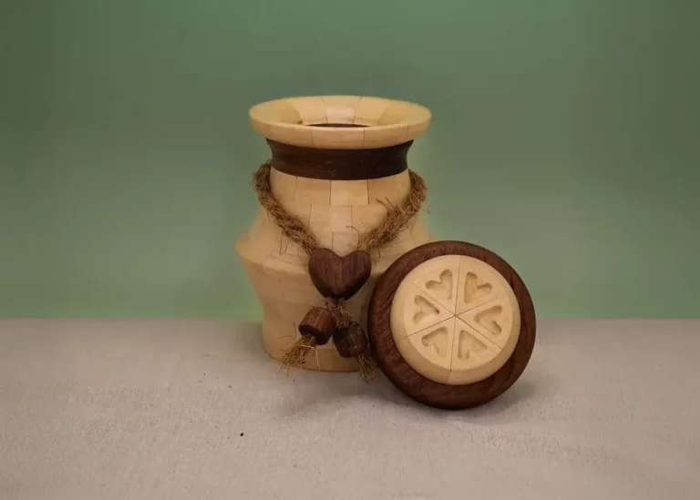 Handgemaakte houten urn met een houten hart en jute touw, ontworpen voor het liefdevol bewaren van as.