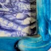 detail van een handgemaakte houten lijst die met aquarel blauw geschilderd is